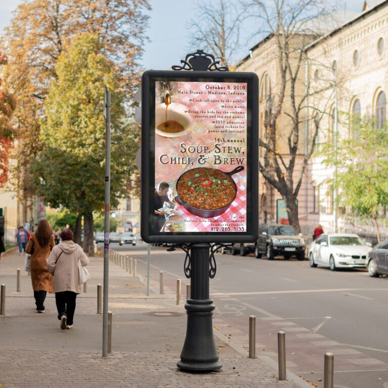 Street sign on a sidewalk with a poster for the Soup, Stew, Chili, and Brew event